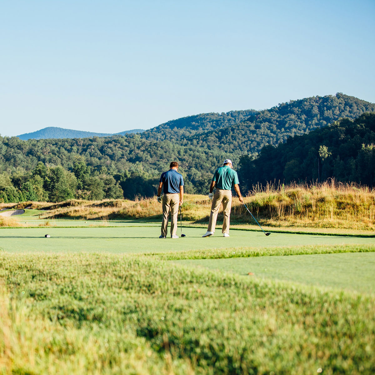 Golfers contemplate their shot on the green at The Cliffs Mountain Park's golf course